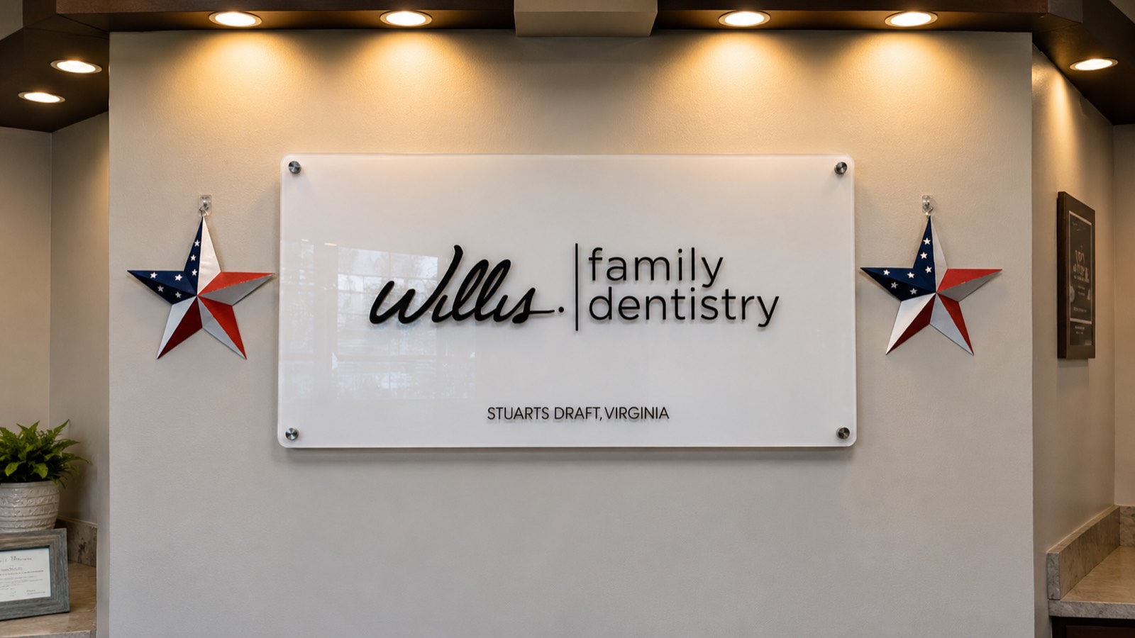 Willis & Associates Family Dentistry lobby sign in Stuarts Draft, Virginia, flanked by two American-flag stars